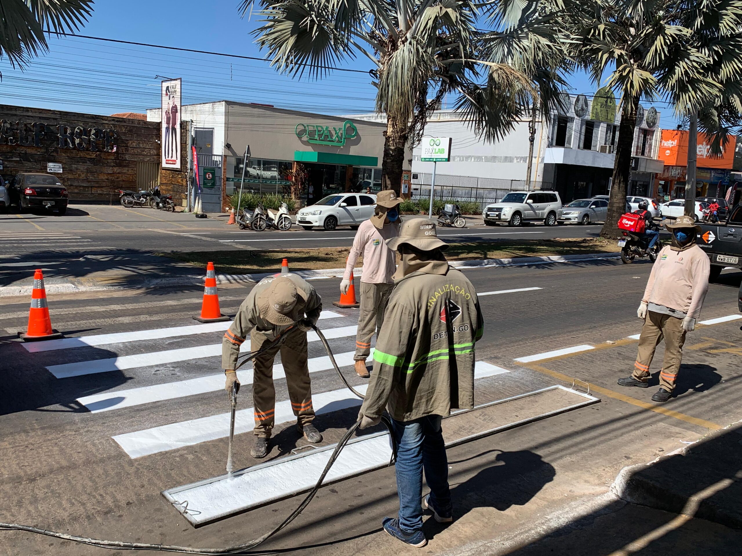 Trabalhadores realizando pintura de faixas em Trindade - Goiás.